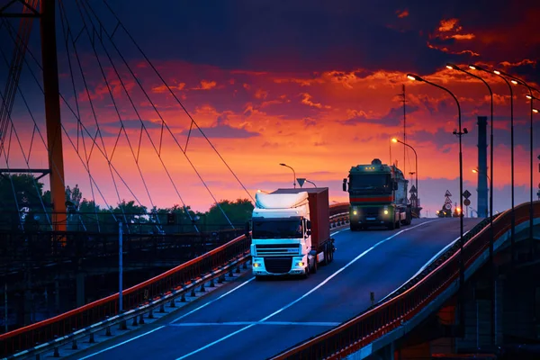 LKW mit Containerfahrten über die Brücke, schöner Sonnenuntergang, Güterwagen im Industriehafen, die Straße geht nach oben — Stockfoto