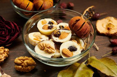 Kırsal masada ev yapımı çikolatalı şekerler, kuru meyve, gül çiçeği ve cevizle süslenmiş.