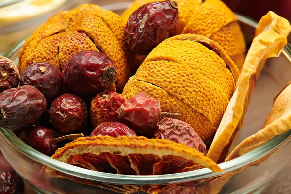 Dry dogrose and tangerine in a vase on wooden table — Stock Photo, Image