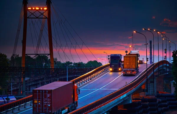 Gün batımında konteynır taşıyan kamyon, demiryolu taşımacılığı endüstriyel limanda yük vagonları. — Stok fotoğraf
