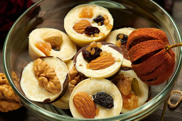 Dulces de chocolate caseros sobre mesa rústica, decorados con frutas secas, flor de rosa y nuez —  Fotos de Stock