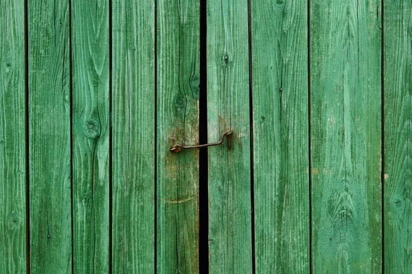 Żelazny zamek i zielone drewniane bramy zbliżenie na farmie domu dla tła lub tekstury — Zdjęcie stockowe