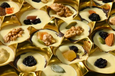 Arka plan için el yapımı çikolata şekerlemeleri, ceviz, kurutulmuş meyve ve şekerle süslenmiş tatlı yiyecekler.