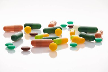 Beyaz arka planda çeşitli haplar, haplar ve vitaminler. Küresel sağlık hizmeti kavramı. Antibiyotik ilaç direnci. Antimikrobik kapsül hapları. İlaç sanayisi. Eczane.