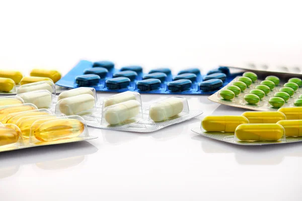 Различные таблетки, таблетки и витамины в блистерной упаковке на белом фоне. Глобальная концепция здравоохранения. Антибиотики лекарственной устойчивости. Антимикробные капсулы. Фармацевтическая промышленность. Аптека . — стоковое фото