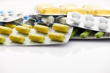 Beyaz arka planda çeşitli tabletler, haplar ve vitaminler. Küresel sağlık hizmeti kavramı. Antibiyotik ilaç direnci. Antimikrobik kapsül hapları. İlaç sanayisi. Eczane.