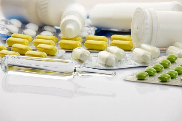 Beyaz arka planda çeşitli tabletler, haplar ve vitaminler. Küresel sağlık hizmeti kavramı. Antibiyotik ilaç direnci. Antimikrobik kapsül hapları. İlaç sanayisi. Eczane. — Stok fotoğraf