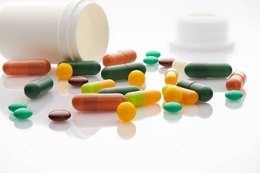 Beyaz arka planda çeşitli haplar, haplar ve vitaminler. Küresel sağlık hizmeti kavramı. Antibiyotik ilaç direnci. Antimikrobik kapsül hapları. İlaç sanayisi. Eczane.