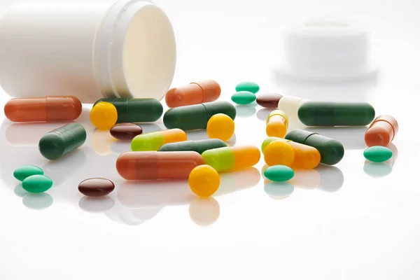 Különböző tabletták, tabletták és vitaminok fehér alapon. Globális egészségügyi koncepció. Antibiotikum gyógyszerrezisztencia. Antimikrobiális kapszula tabletták. Gyógyszeripar. Gyógyszertár. — Stock Fotó