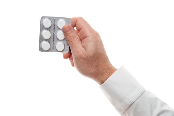 Uomo mano con pillole blister isolato su sfondo bianco. Camicia bianca, stile business. Medicamenti e integratori alimentari per l'assistenza sanitaria. Industria farmaceutica. Farmacia . — Foto Stock