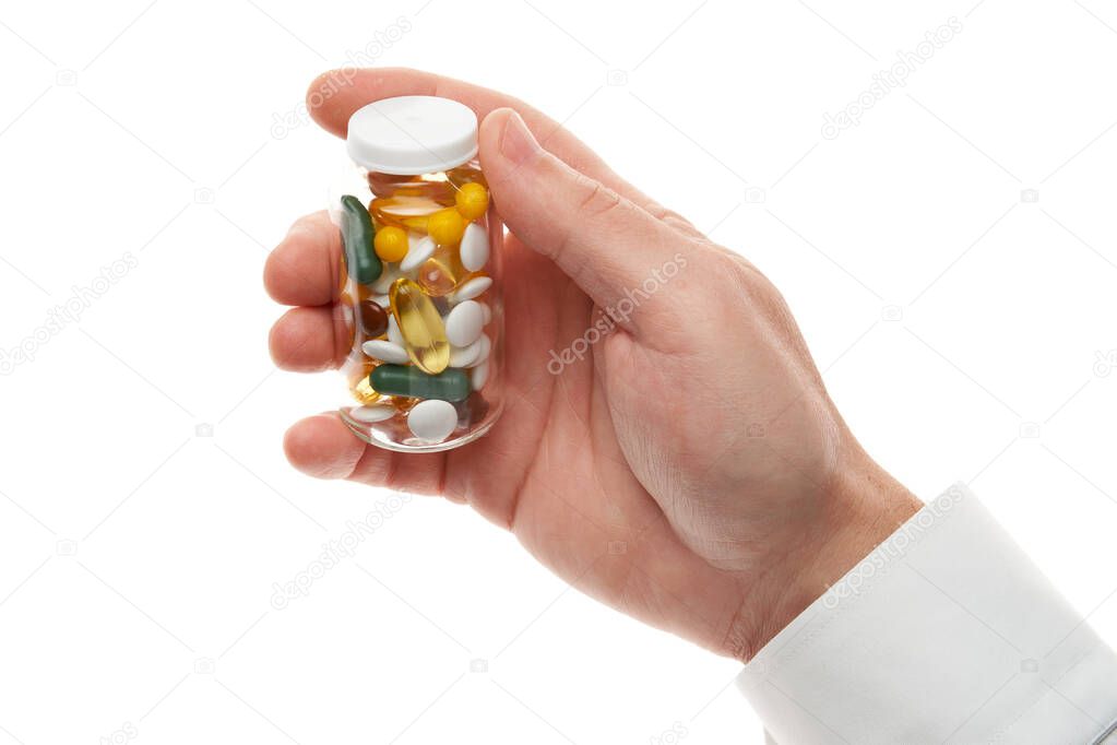 Man hand with glass bottle full of pills, tablets, vitamins, drugs, capsules isolated on white background. White shirt, business style. Health care concept. Pharmaceutical industry. Pharmacy.