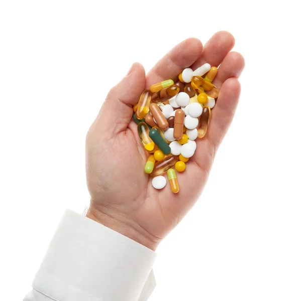Férfi kéz maroknyi tablettát, tablettát, vitaminokat, gyógyszereket, kapszulákat izolált fehér alapon. Fehér ing, üzleti stílus. Egészségügyi koncepció. Gyógyszeripar. Gyógyszertár. — Stock Fotó