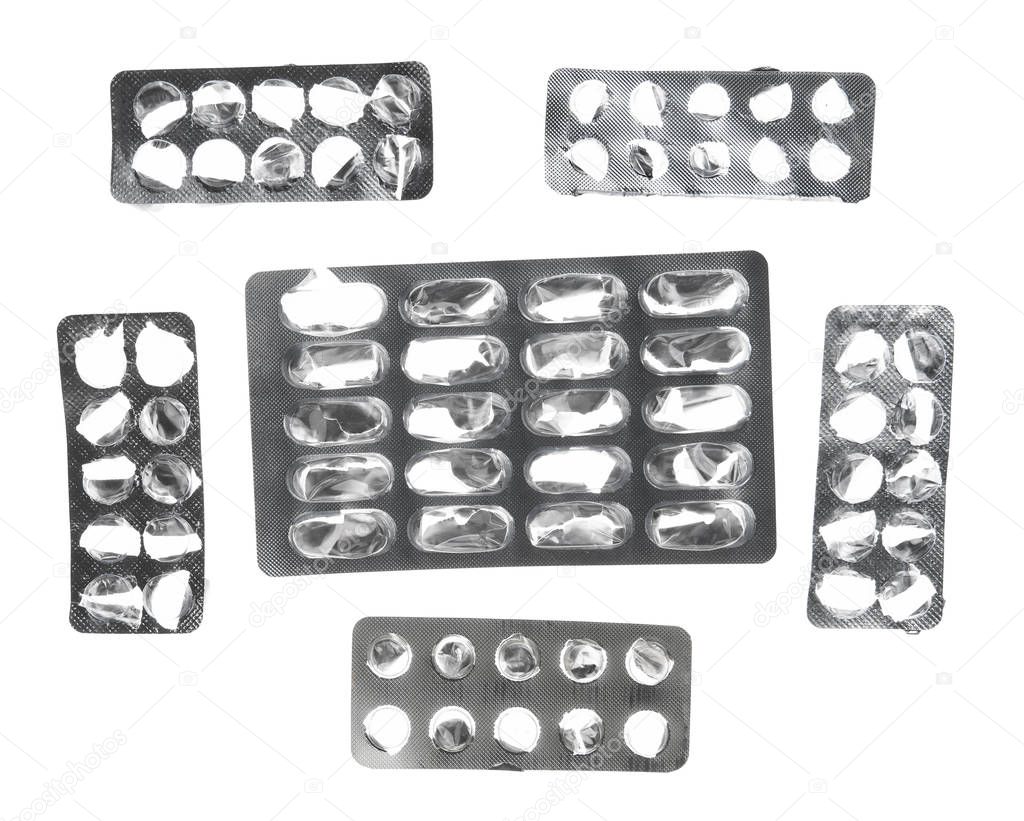 Used pills blisters, empty, opened with no pills on white background - health care and medicines concept. Pharmaceutical industry. Pharmacy.