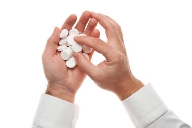 Man hand with handful of big white pills isolated on white background. White shirt, business style. Medicament and food supplement for health care. Pharmaceutical industry. Pharmacy.