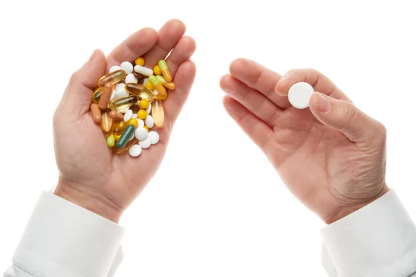 人的手从一把药丸，药片，维生素，药物，胶囊中提取一片药丸，这些药丸在白色背景下被分离出来。 白色衬衫，商务风格。 卫生保健概念。 制药工业。 药学. — 图库照片