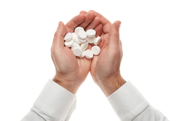 Mão de homem com um punhado de grandes pílulas brancas isoladas no fundo branco. Camisa branca, estilo de negócio. Medicamento e suplemento alimentar para cuidados de saúde. Indústria farmacêutica. Farmácia . — Fotografia de Stock