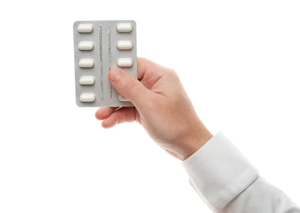 Uomo mano con pillole blister isolato su sfondo bianco. Camicia bianca, stile business. Medicamenti e integratori alimentari per l'assistenza sanitaria. Industria farmaceutica. Farmacia . — Foto Stock