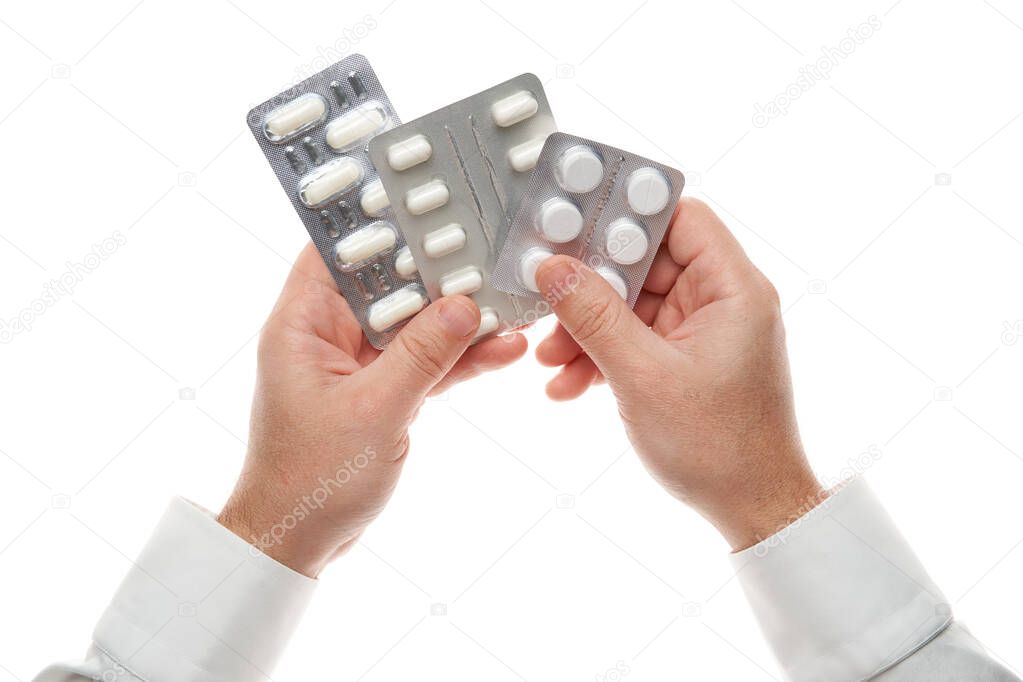 Man hand with pills blister isolated on white background. White shirt, business style. Medicament and food supplement for health care. Pharmaceutical industry. Pharmacy.