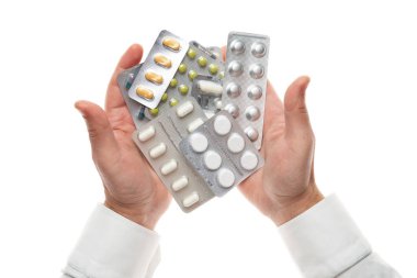 Man hand with pills blister isolated on white background. White shirt, business style. Medicament and food supplement for health care. Pharmaceutical industry. Pharmacy.