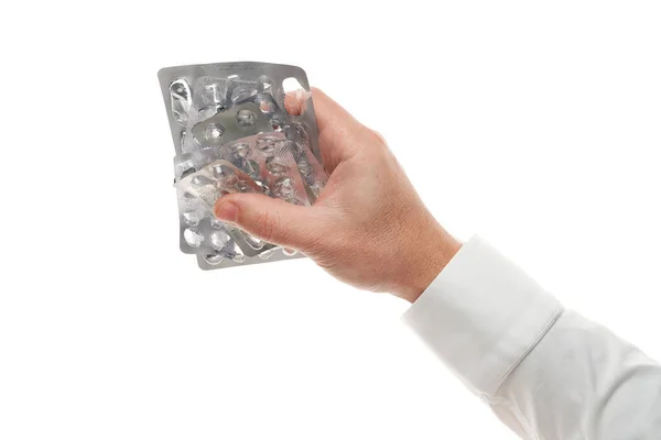 Mano de hombre con ampolla de píldoras usadas aislada sobre fondo blanco. Camisa blanca, estilo de negocios. Medicamento y complemento alimenticio para la atención médica. Industria farmacéutica. Farmacia . — Foto de Stock