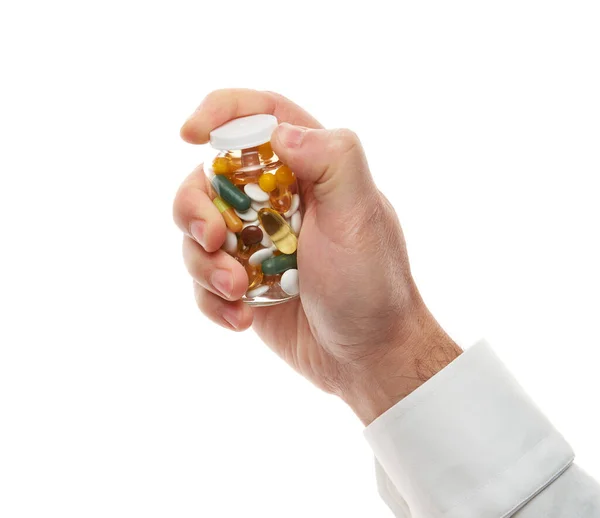 Man hand opening glass bottle full of pills, tablets, vitamins, drugs, capsules isolated on white background. White shirt, business style. Health care concept. Pharmaceutical industry. Pharmacy. — Stockfoto