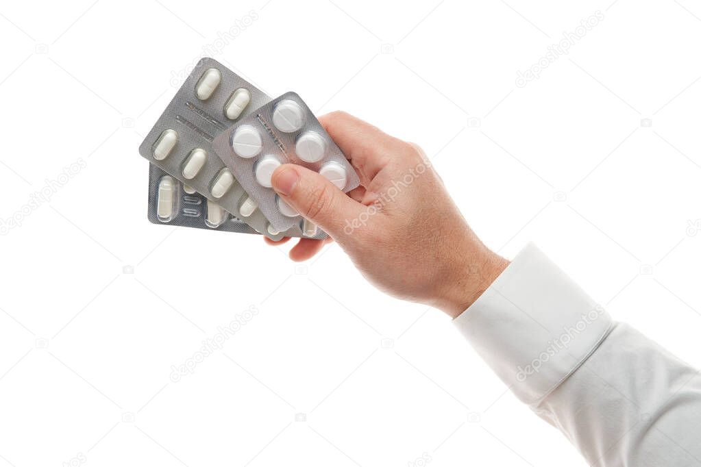 Man hand with pills blister isolated on white background. White shirt, business style. Medicament and food supplement for health care. Pharmaceutical industry. Pharmacy.