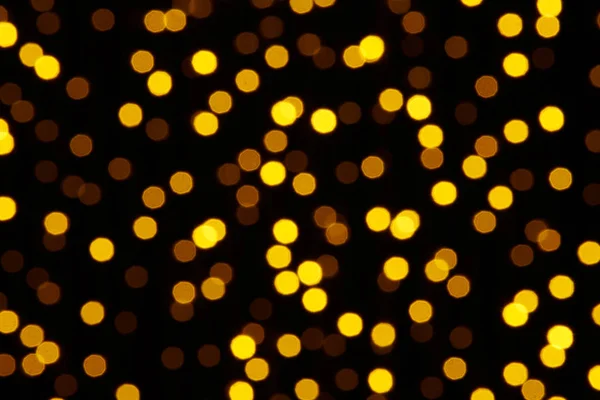 Fundo abstrato - foto de bokeh amarelo em um preto — Fotografia de Stock