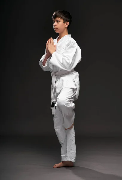 武道の服装をした10代の若者は濃い灰色の背景スポーツの概念に身を包み — ストック写真