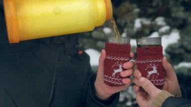  Kadın ormanda, güzel kış manzara karlı köknar ağaçları ile sıcak çay içiyor.