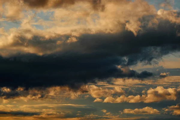 Beautiful dramatic sky with dark and bright clouds at sunset, summer landscape, golden sunlight — Stock Photo, Image