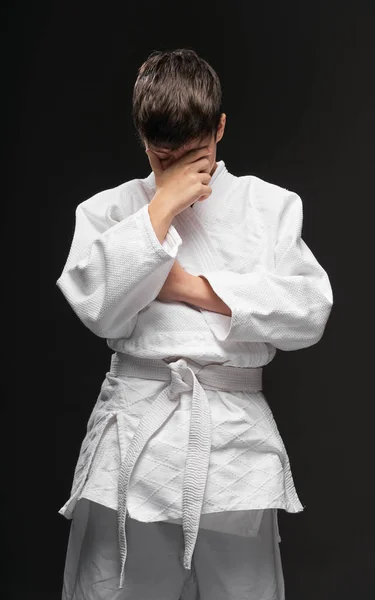 暗い灰色の背景スポーツの概念に問題がある武道の服を着た悲しい10代の若者 — ストック写真
