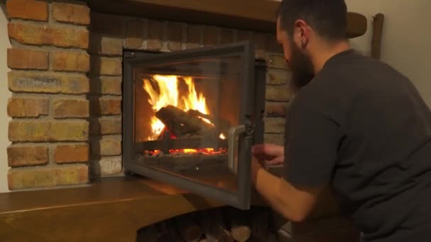 Ein Mann Macht Ein Feuer Legt Holz Den Kamin — Stockvideo