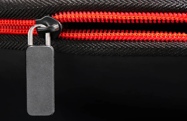 Empty grey label and red zipper fastener on black, close-up, macro, empty space for text — Stock Photo, Image