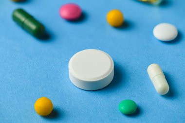 Hapların, tabletlerin, vitaminlerin, uyuşturucunun, omega 3 balık yağının, jel kapsüllerinin, sağlık hizmetleri için mavi üzerine ilave gıdanın arka planı