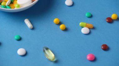 Hapların, tabletlerin, vitaminlerin, uyuşturucunun, omega 3 balık yağının, jel kapsüllerinin, sağlık hizmetleri için mavi üzerine ilave gıdanın arka planı