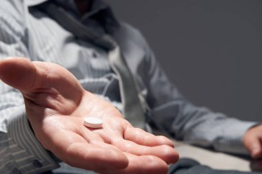 Bir hapı olan işadamı, elleri yakın görüş - zorluklar, depresyon, sorunlar, sağlık ve stres kavramı, modern iş riski