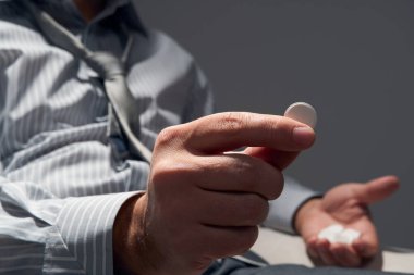 Bir hapı olan işadamı, elleri yakın görüş - zorluklar, depresyon, sorunlar, sağlık ve stres kavramı, modern iş riski