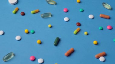Hapların, tabletlerin, vitaminlerin, uyuşturucunun, omega 3 balık yağının, jel kapsüllerinin, sağlık hizmetleri için mavi üzerine ilave gıdanın arka planı