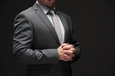 Gri takım elbiseli iş adamı portresi, koyu duvar arkaplanı