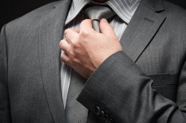 Gri takım elbiseli iş adamı portresi, koyu duvar arkaplanı