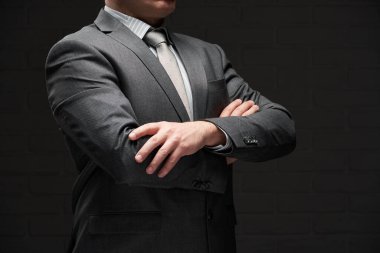 Gri takım elbiseli iş adamı portresi, koyu duvar arkaplanı