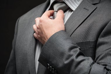 Gri takım elbiseli iş adamı portresi, koyu duvar arkaplanı