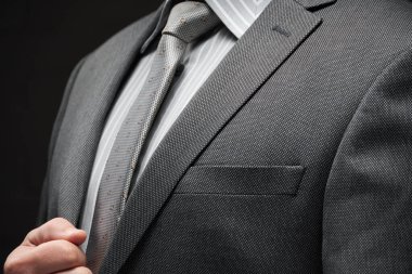 Gri takım elbiseli iş adamı portresi, koyu duvar arkaplanı