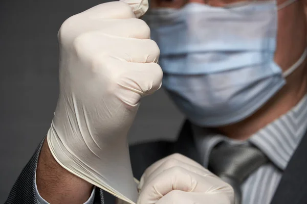 Mężczyzna Maską Twarzy Ochrony Antywirusowej Zakłada Sterylne Rękawice Medyczne Koncepcja — Zdjęcie stockowe