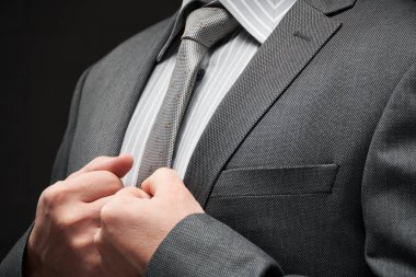 Gri takım elbiseli iş adamı portresi, koyu duvar arkaplanı