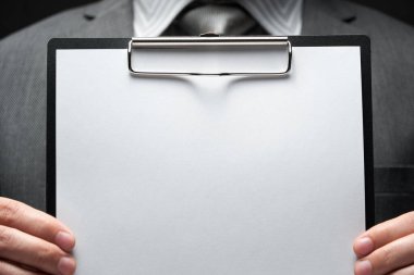 Beyaz boş kağıt sayfa, iş adamı eli, gri takım elbise, koyu duvar arkaplan, metin için boş alan