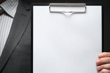 Beyaz boş kağıt sayfa, iş adamı eli, gri takım elbise, koyu duvar arkaplan, metin için boş alan