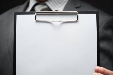 Beyaz boş kağıt sayfa, iş adamı eli, gri takım elbise, koyu duvar arkaplan, metin için boş alan