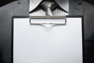 Beyaz boş kağıt sayfa, iş adamı eli, gri takım elbise, koyu duvar arkaplan, metin için boş alan