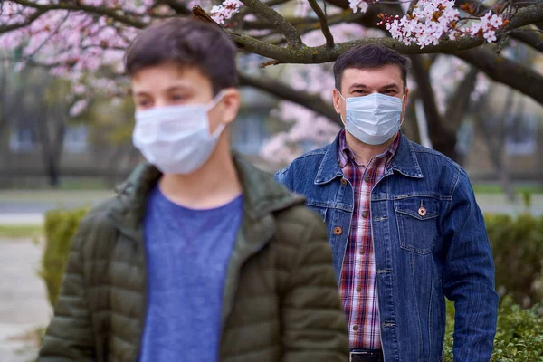 Far Och Son Med Ansiktsmask Finns Staden Utomhus Blommande Träd — Stockfoto